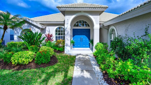 A house with a blue front door, arched entrance, and a tiled roof.