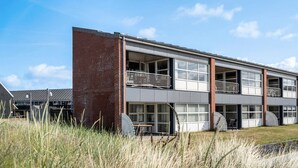 Een modern, tweelaags gebouw met grote ramen en een bakstenen gevel.