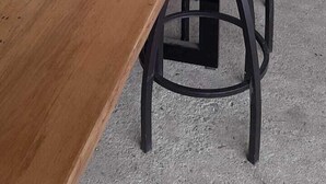 Uma mesa de jantar com cadeiras, uma peça decorativa, uma geladeira e um fogão.