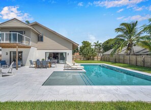 A two-story house with a swimming pool, patio furniture, and a wooden fence. - Wonderful Tropical Pool House East Delray Near Ocean (Delray Beach)