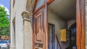 Eine Holztür mit einem Steinsäule, einem kleinen Fenster und einem gelben Gegenstand an der Wand.