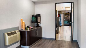 Ein Flur mit einer Rezeption, einer Kaffeemaschine und einem Wasserspender.