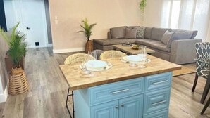 A modern living room with a sofa, coffee table, and dining area. - Amazing bohemian house with a pool in a very nice neighborhood  (Sunrise)
