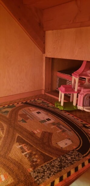 A dollhouse interior with a train track layout on the floor.