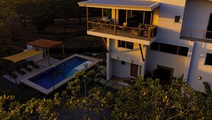 A modern two-story house with a rooftop terrace, a swimming pool, and a covered patio area. - OCEANVIEWS AND SHORT WALK TO PLAYA NEGRA IN GATED COMMUNITY WITH SECURITY (Los Pargos)