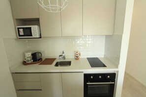 Una cocina moderna equipada con microondas, cafetera, fregadero y horno.