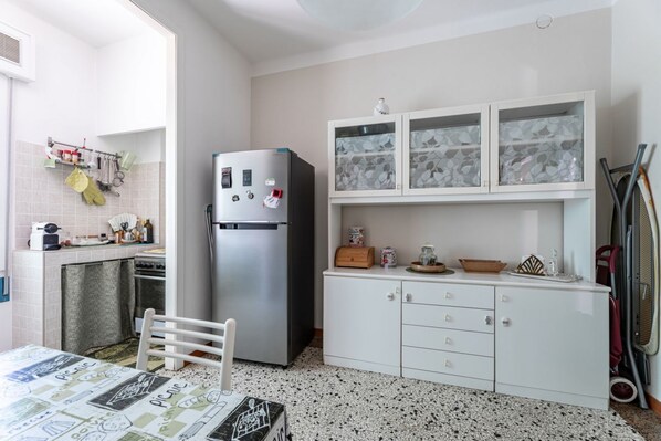 Réfrigérateur, un four, surface de cuisson, vaisselle et ustensiles
