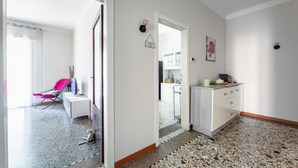 A modern interior with a kitchen area, a dining table, and a chair.