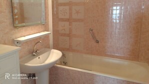 A bathroom with a sink, mirror, and shower.