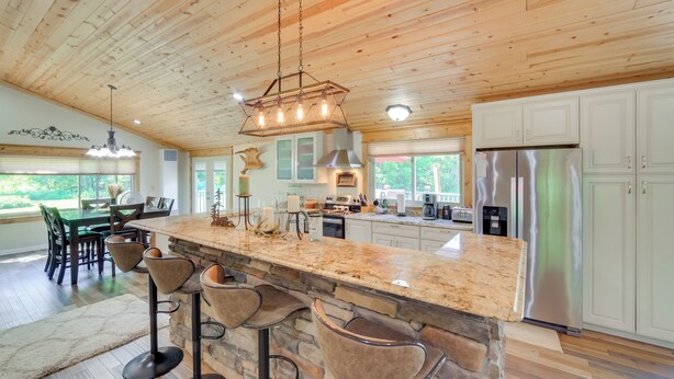 A spacious kitchen with a large island, bar stools, and a stainless steel refrigerator. - Champion Vacation Rental with Fire Pit! (Champion)
