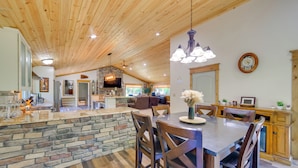 A spacious kitchen with a stone island, wooden ceiling, and a dining area with a large table and chairs. - Champion Vacation Rental with Fire Pit! (Champion)