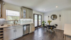 Una cocina moderna con una isla grande, electrodomésticos integrados y un comedor con mesa y sillas.