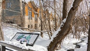Un paisaje nevado con un edificio de madera y un cartel.