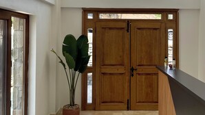 Una cocina moderna con un ventanal grande, puertas de madera y lámparas colgantes.