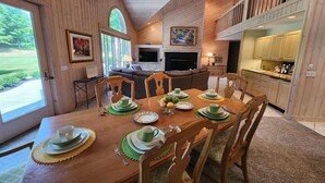 Interior em madeira com sala de jantar, cozinha e área de estar.