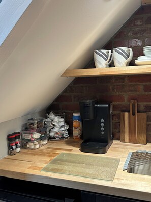 Enjoy cooking in this well-equipped kitchen with a coffee maker, utensils, and storage.