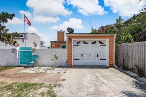 A residential garage with a white door, a satellite dish, and an American flag.