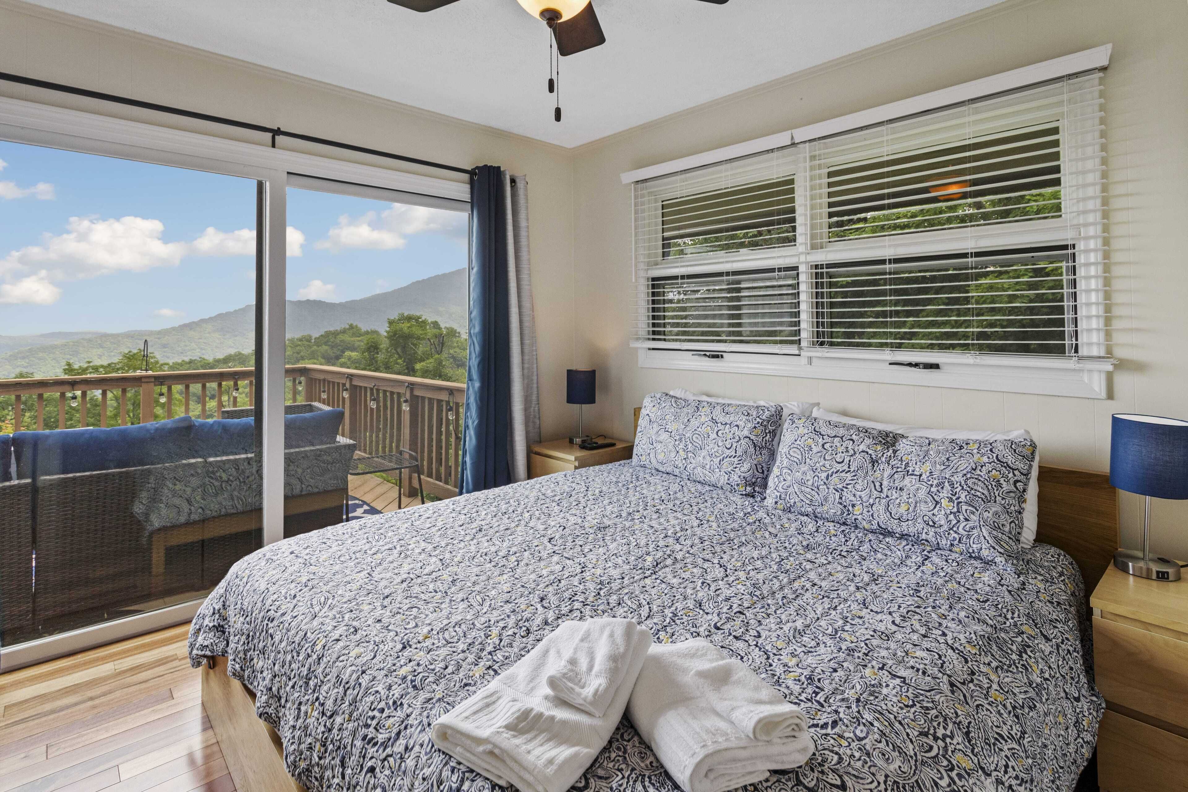 Un dormitorio con una cama grande, vistas al exterior y un balcón.