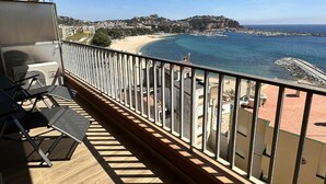 A balcony with a view of a beach and the sea.