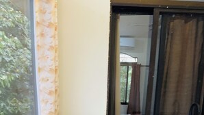 A kitchen with a gas stove, wooden cabinets, and a window with a view of greenery. - Enchanted Monkey Apartment  (Quepos)