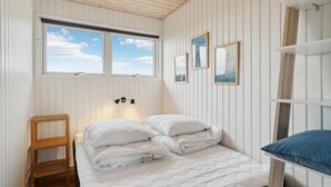 A bedroom with a bed, a wooden chair, a window, and wall-mounted artwork. - 3 bedroom beautiful home in Ebeltoft (Ebeltoft)