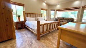 Un dormitorio con una cama y una mesa de madera, además de un sofá.