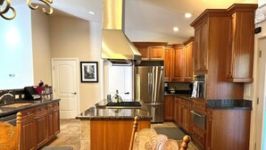 Una cocina moderna con armarios de madera, electrodomésticos de acero inoxidable y una isla central.