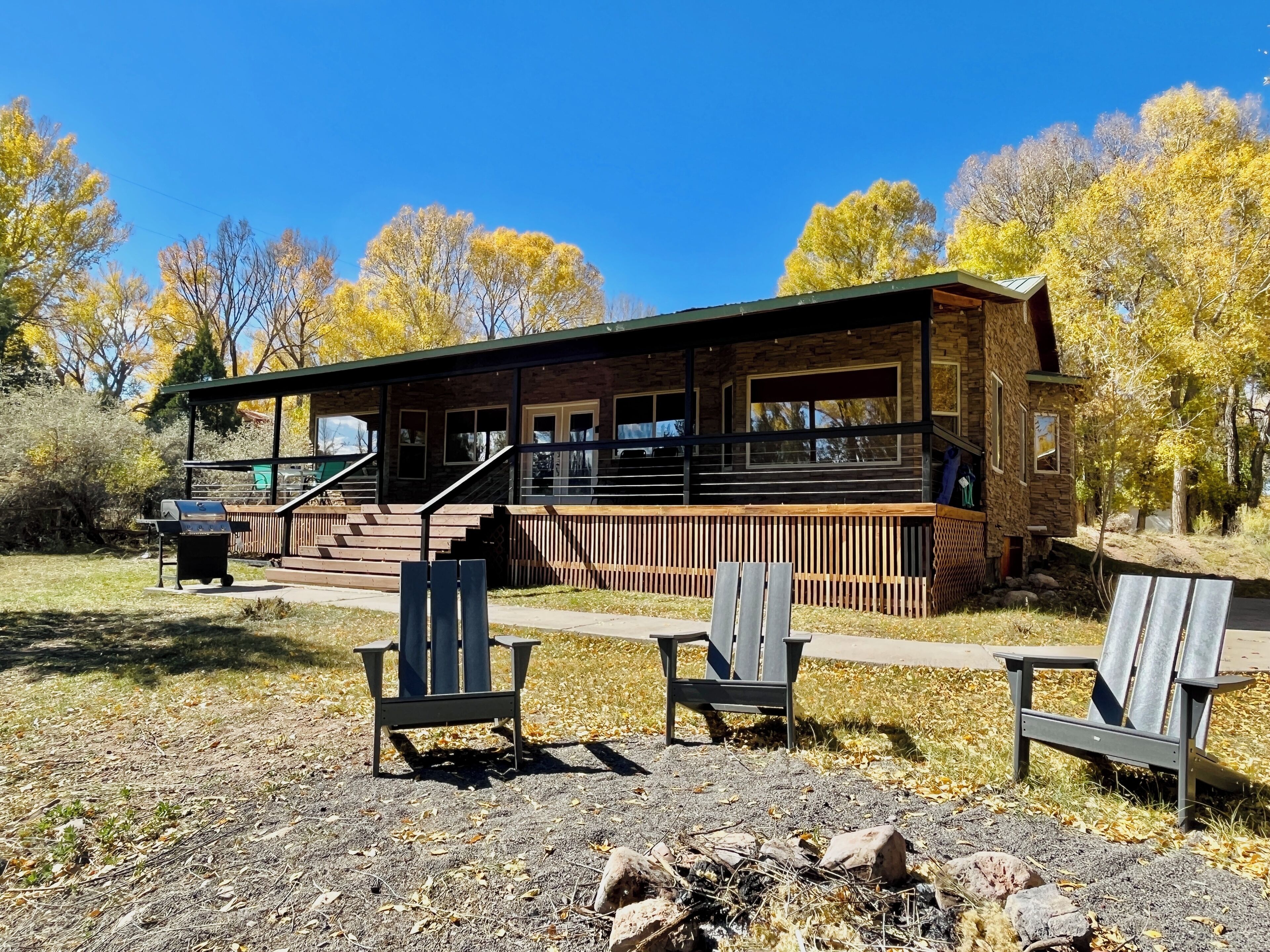 A lodge with a stone exterior, a covered porch, and a fire pit area.