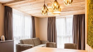 A modern dining area with a wooden table and grey upholstered chairs, a wooden ceiling, and a green wall. - mit 1 Schlafzimmer by Interhome (Fügen)