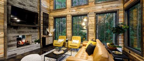 Un salón espacioso con chimenea, ventanas amplias y una zona de estar acogedora.