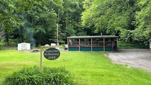 A small cabin labeled "Triple Creek Hideaway 1468" surrounded by lush greenery.