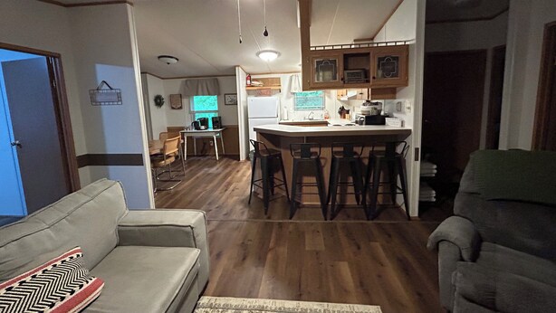 A compact living space with a kitchenette, a dining area, and a seating area with a sofa and a chair.