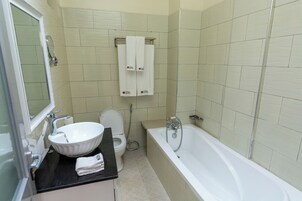 A bathroom with a sink, toilet, and bathtub.