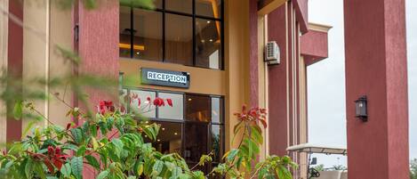 A reception area with a sign, a golf cart, and a building entrance.
