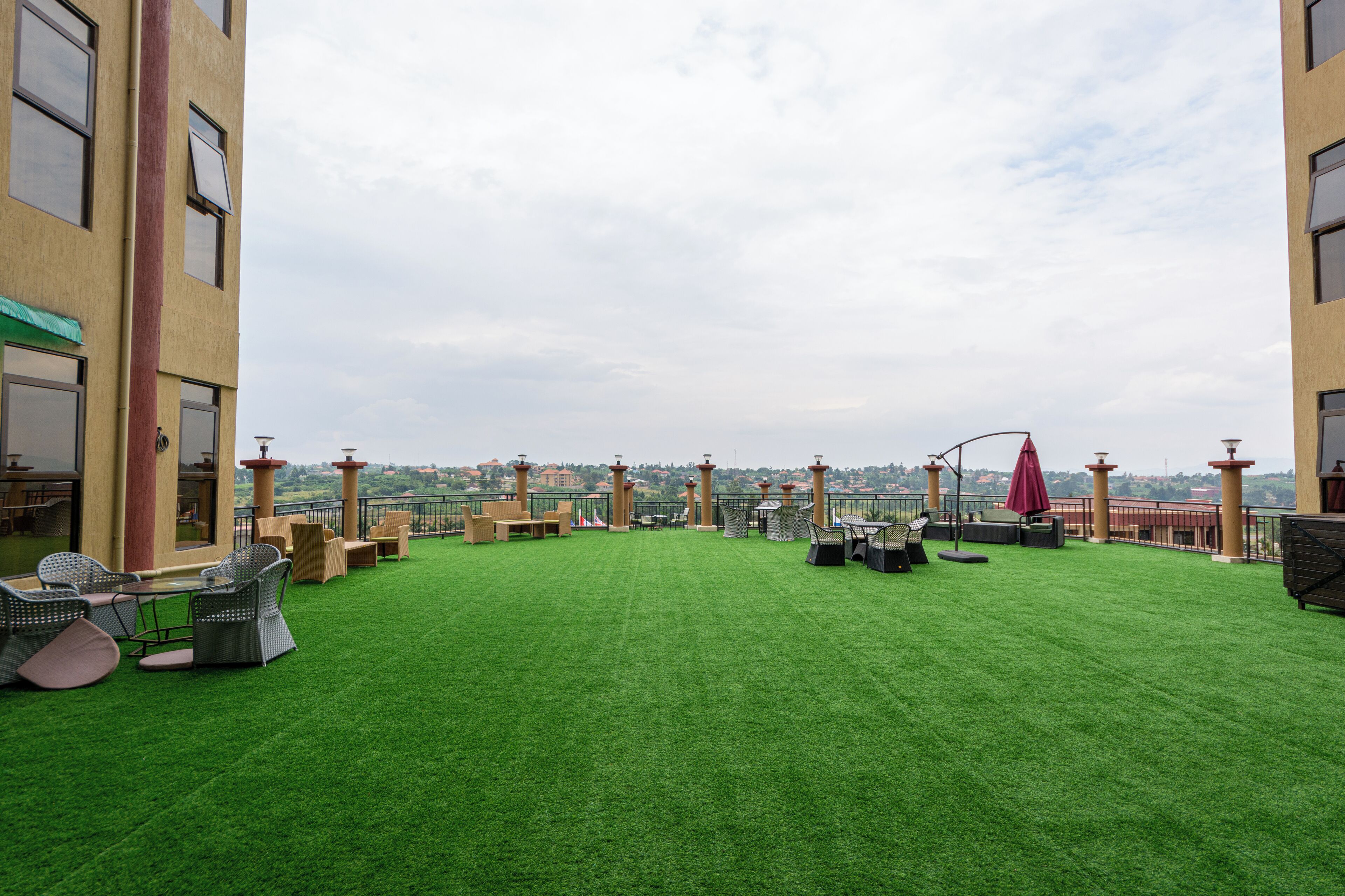 Une terrasse sur le toit, agrémentée de gazon synthétique, de mobilier d’extérieur et offrant une vue sur le paysage urbain.
