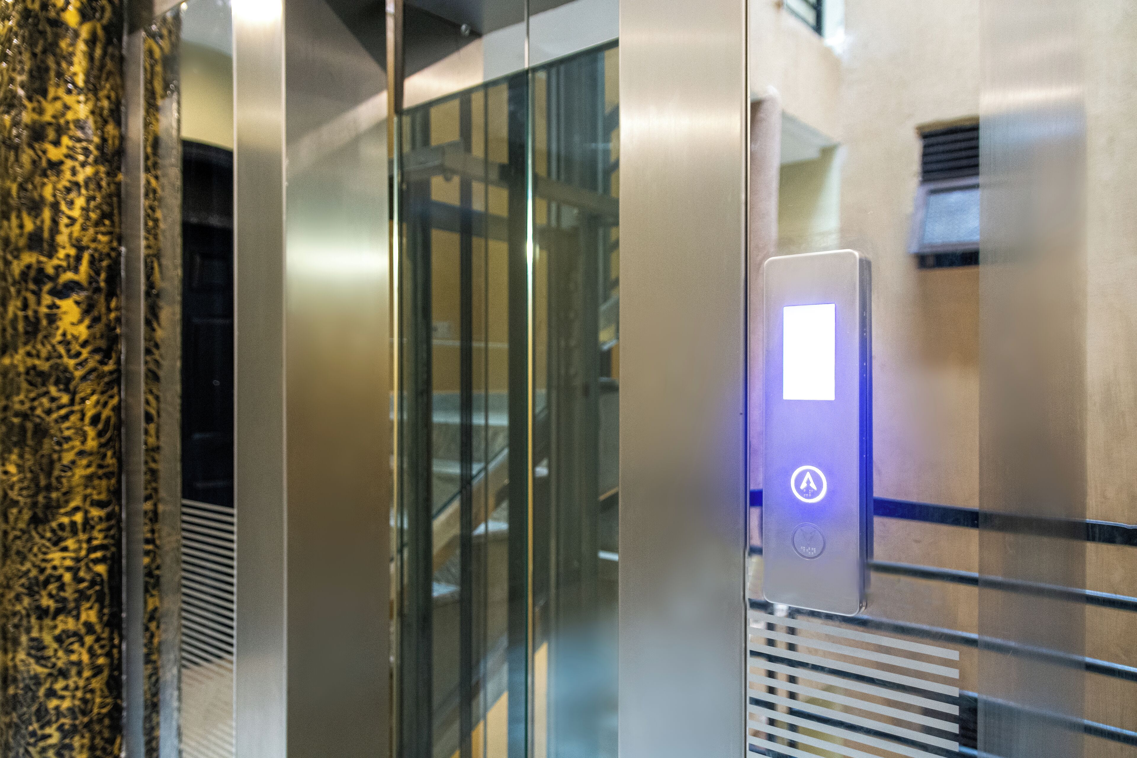 L’intérieur d’un ascenseur, avec un écran numérique et un bouton.