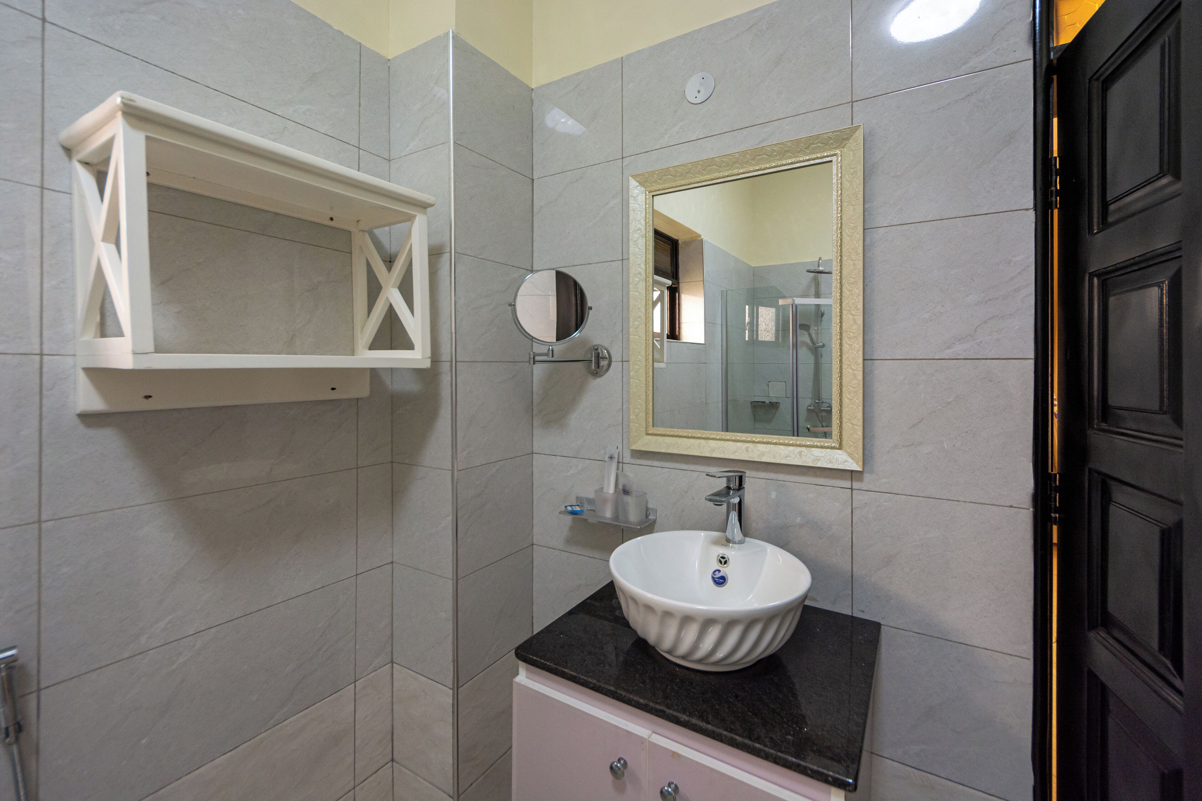 A bathroom with a white pedestal sink, a mirror, and a white medicine cabinet.