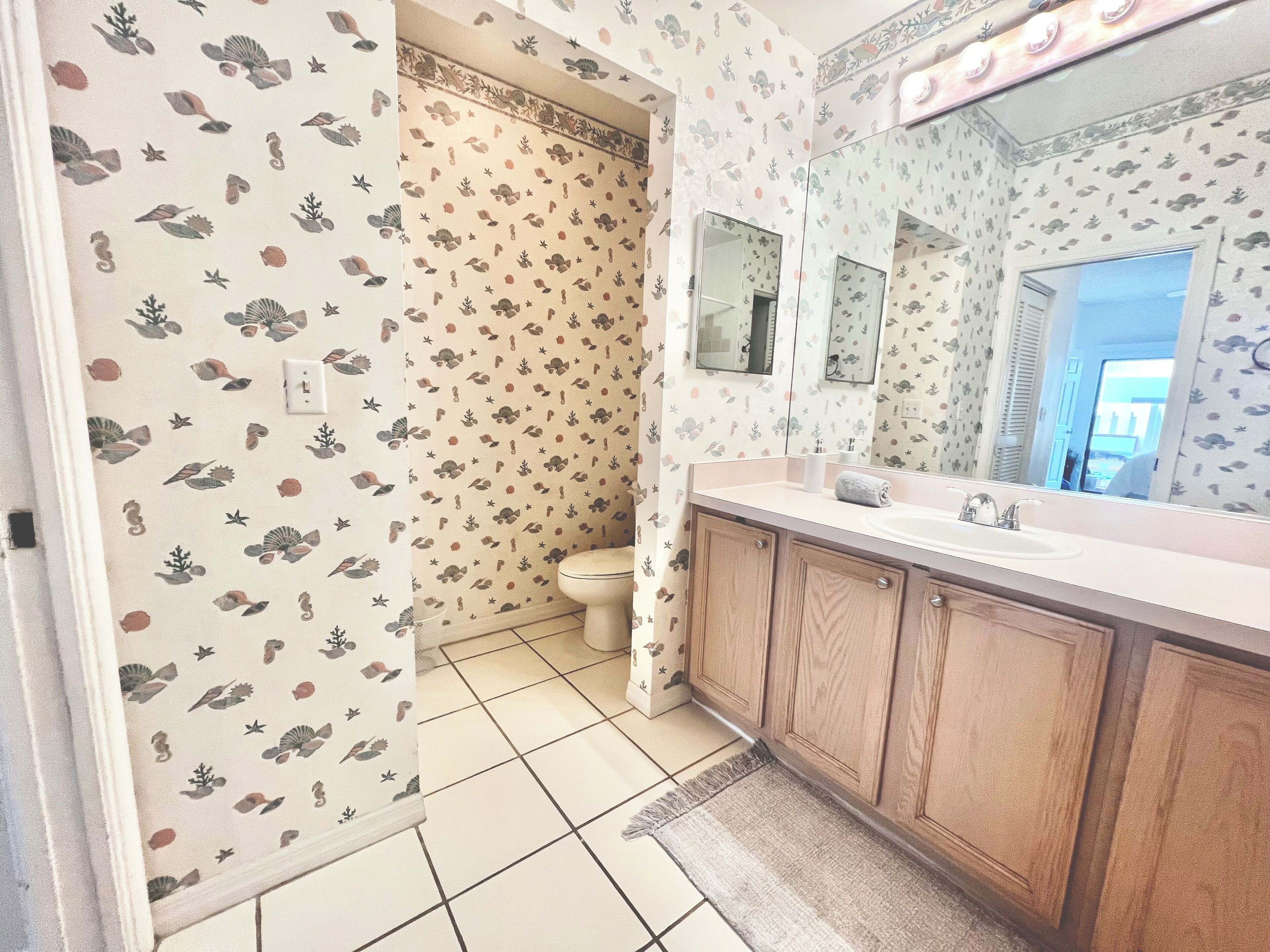 Une salle de bain avec des toilettes, un lavabo et un miroir.