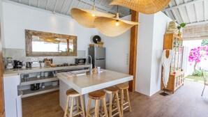 A modern kitchen with a central island, wooden stools, and hanging wicker lamps. - Villa M2 by Alfred in Bali (Seminyak)