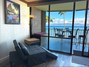 Enjoy the ocean view from your balcony, featuring a comfortable sofa and chairs.