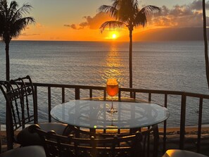 Relax in a tranquil oceanfront setting with a glass table and chairs, perfect for taking in the view.