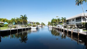 A marina with boats docked, surrounded by palm trees and modern buildings. - RENOVATED 2 Bed, 2 Bath 1st floor with heated pool on the bay! (Naples)