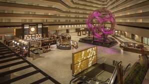 Eine moderne Hotellobby mit einer zentralen Lounge, einer großen Dekoration und einer Bar.