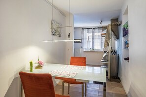 Un coin repas avec une table, des chaises et un vase de fleurs.