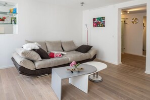 Un salon moderne avec un canapé, une table basse et un tableau accroché au mur.