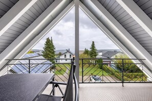 Un balcon avec une balustrade en métal, une table et une chaise.