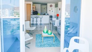 Ein modernes Apartment mit Balkon, Küchenzeile und Essbereich.