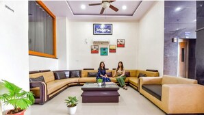 Una sala moderna con un sofá modular, una mesa de centro y dos plantas en macetas.