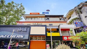 Un immeuble à plusieurs étages, sur lequel on peut voir une enseigne « Hôtel Apollo », une enseigne « Fabexpress » et un magasin « Skechers ».