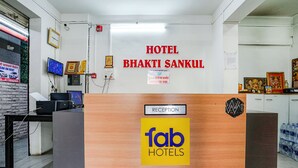 A reception desk with a sign for "Hotel Bhakti Sankul" and a "Reception" sign above it. - Fabhotel Bhakti Sankul (Nashik)